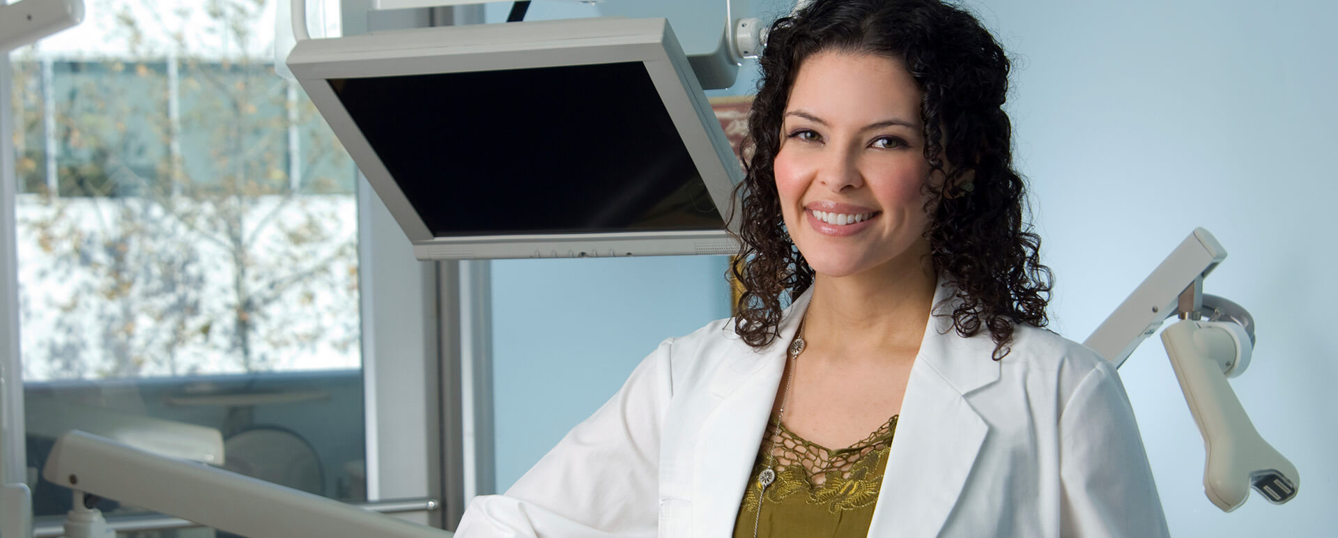 dentist standing in front of dental equipment
